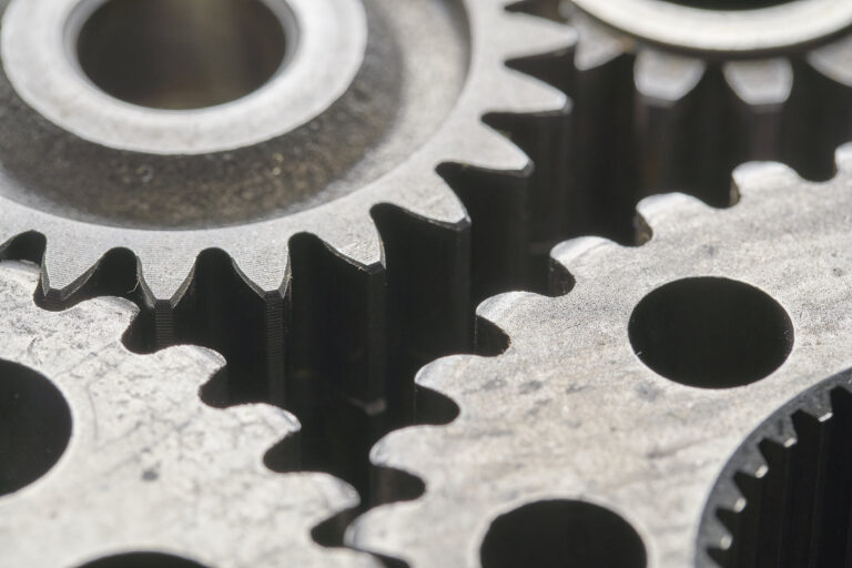Close-up view of interlocking metallic gears with visible teeth and circular holes.