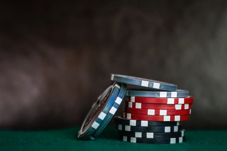 Stack of blue, red, and black poker chips on green felt surface.