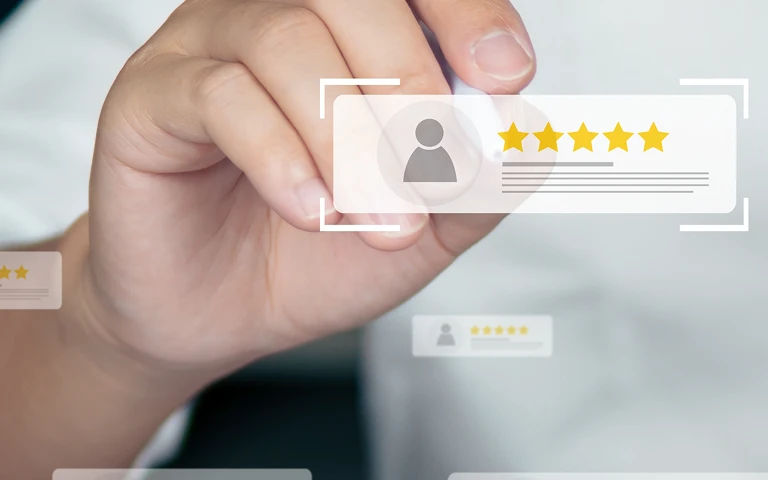 Close-up of hand interacting with digital five-star user rating interface.