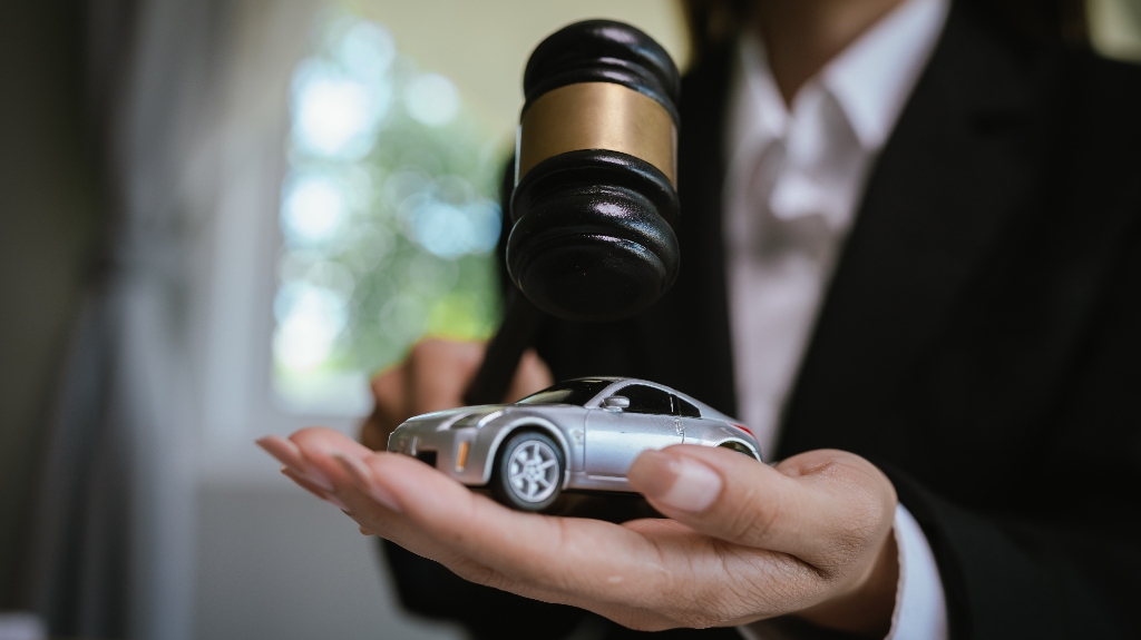 Lawyer is holding car model and judge's gavel