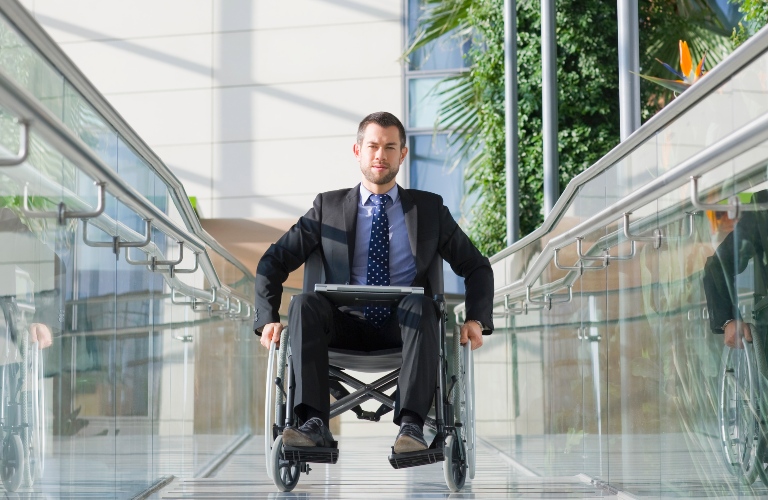front view of a businessman in a wheelchair on the pedestrian bridge